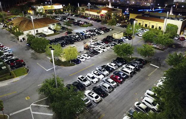 An aerial view of the outdoor LED lighting at The Palms Town 国家 building and parking lot at night